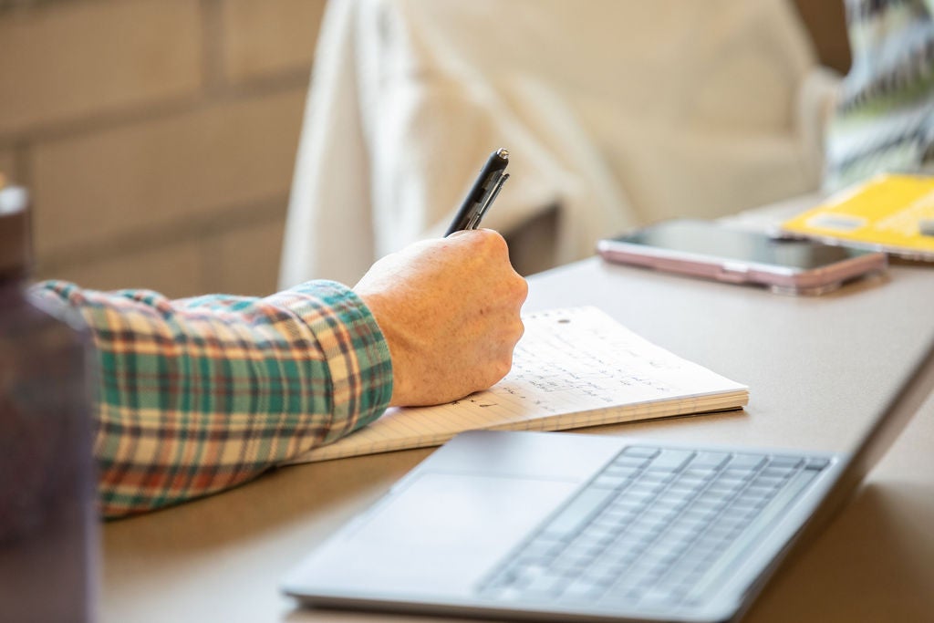 A student takes notes in a journal