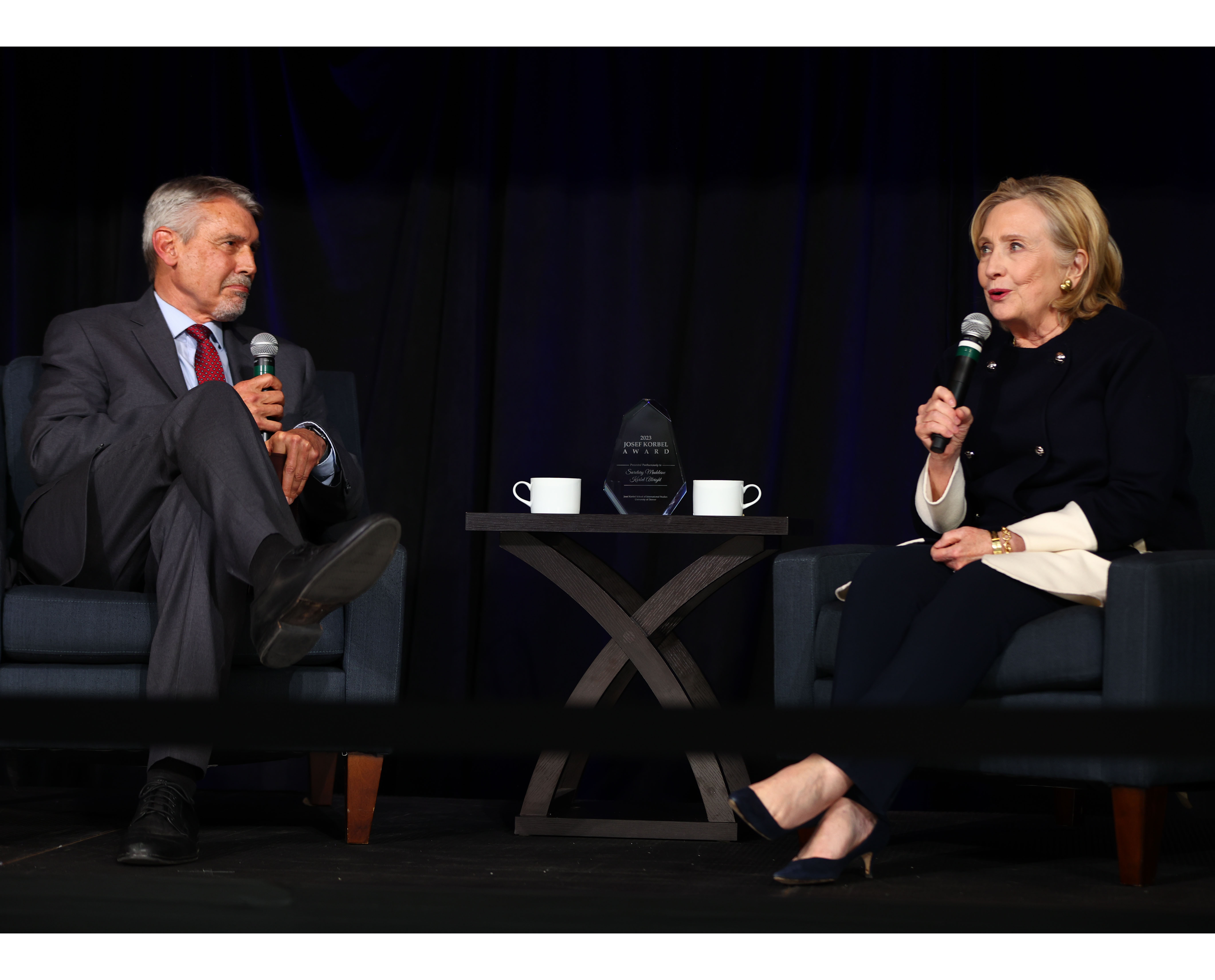 Hillary Clinton speaks with Fritz Mayer on stage.