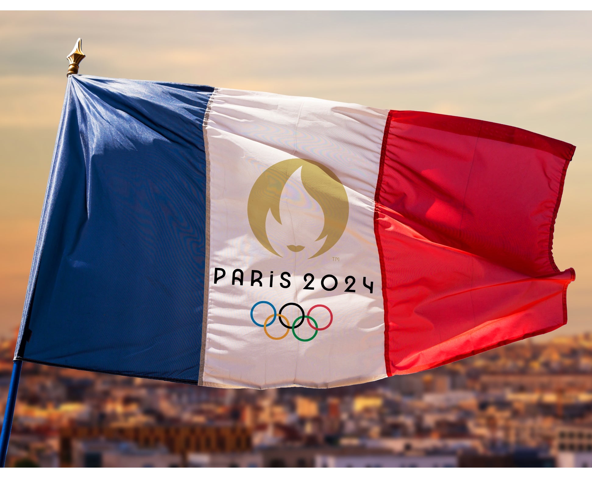 A French flag featuring the Olympic rings and the words Paris 24 flies on a flagpole over the city.