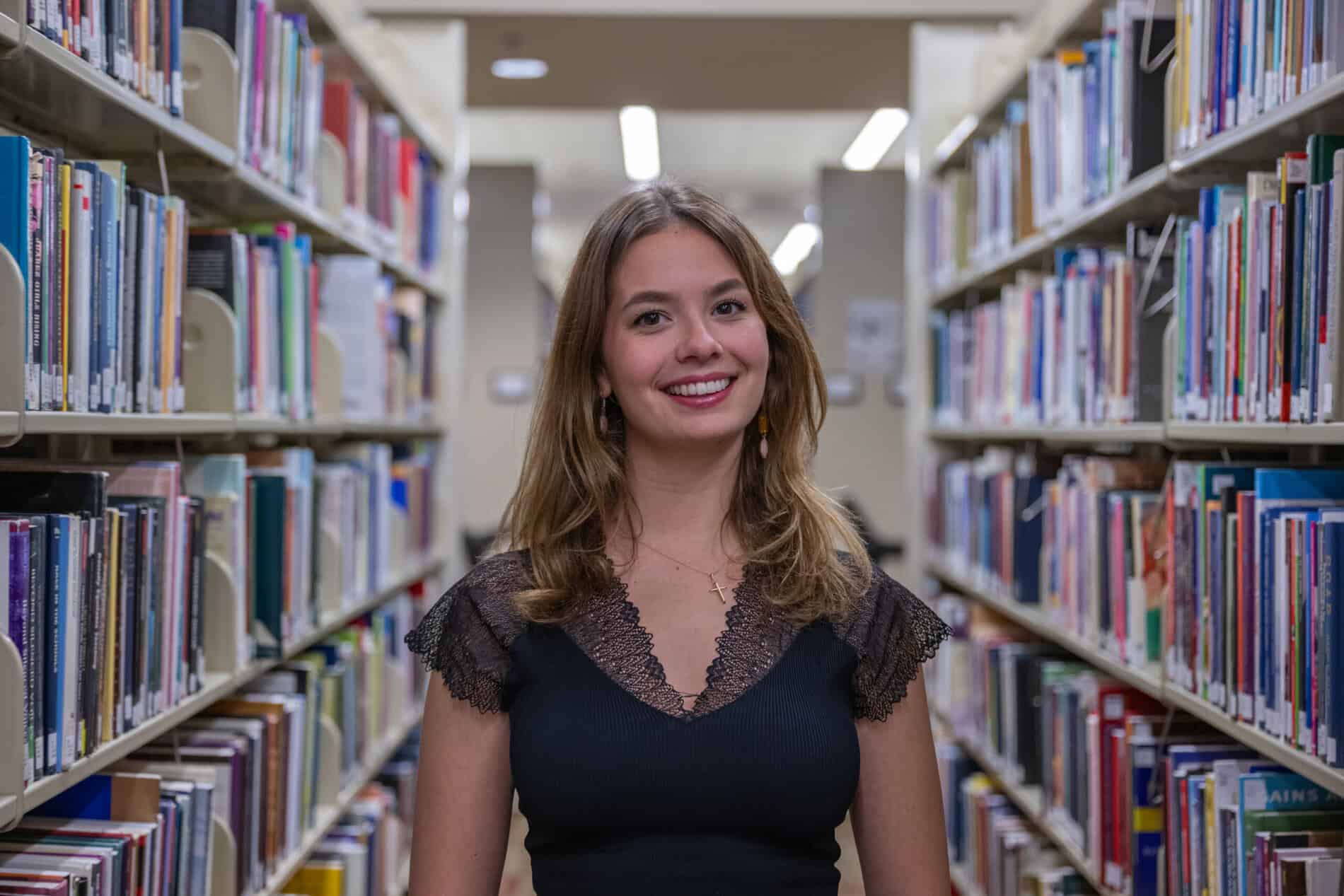 Female Korbel student in library stacks