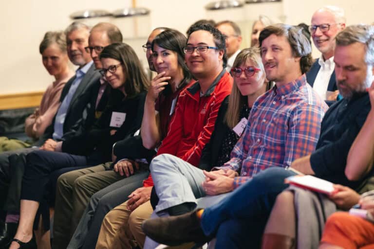 Students sitting in a row participating in a lecture.
