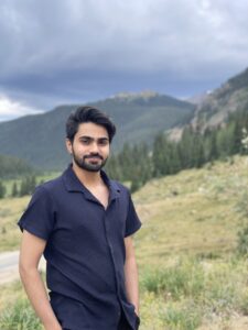 Ahmad Saleem poses in front of a mountain